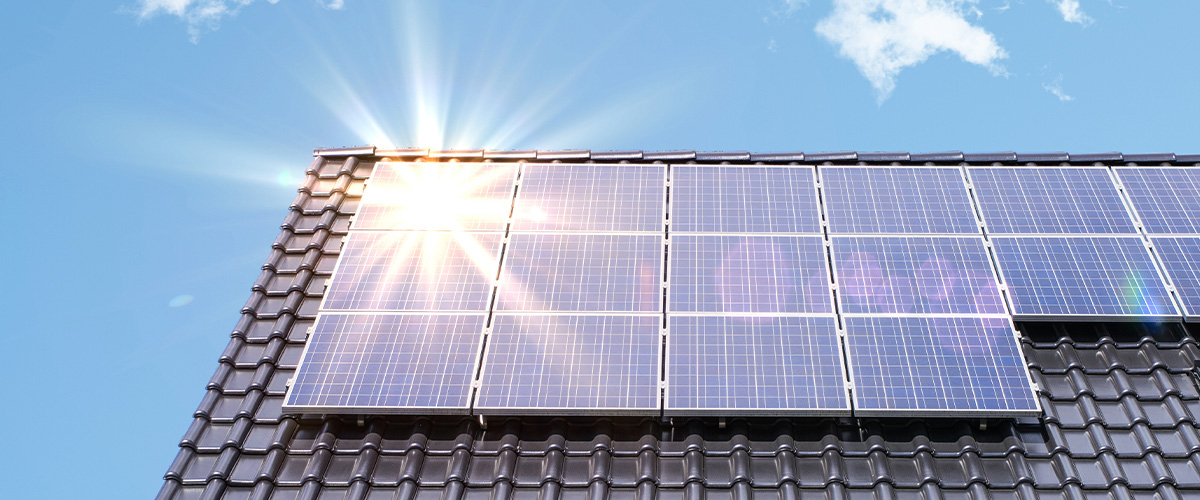 Solaranlage auf dem Dach eines Hauses im Sonnenlicht – Symbolbild für die Nutzung von Photovoltaik zur Senkung der Energiekosten inklusive staatlicher Fördermöglichkeiten für erneuerbare Energien.