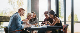 Studenten bereiten sich gemeinsam auf das Studium vor – ideal für Themen wie Versicherungen und finanzielle Absicherung zum Studienbeginn.