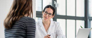 Eine Ärztin spricht in einer Praxis mit einer Patientin – persönliche medizinische Beratung im Kontext geplanter Reformen im Gesundheitswesen und möglicher Auswirkungen auf die Versorgung.