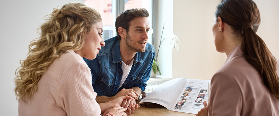 Ein Paar bespricht mit einer Finanzcoach der DVAG Unterlagen zur Altersvorsorge – persönliche Beratung zu den Auswirkungen der Riester-Reform und den passenden Vorsorgemöglichkeiten.